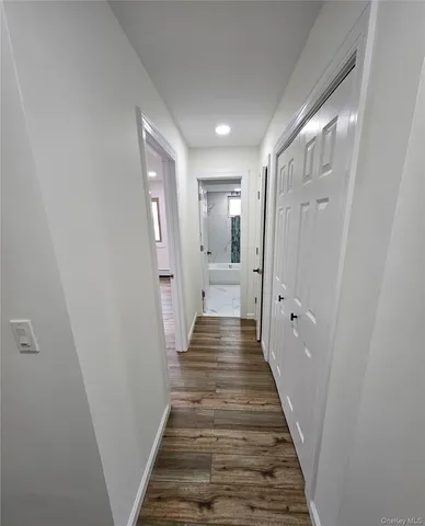 a view of a hallway with wooden floor and staircase