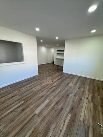 an empty room with wooden floor and entrance