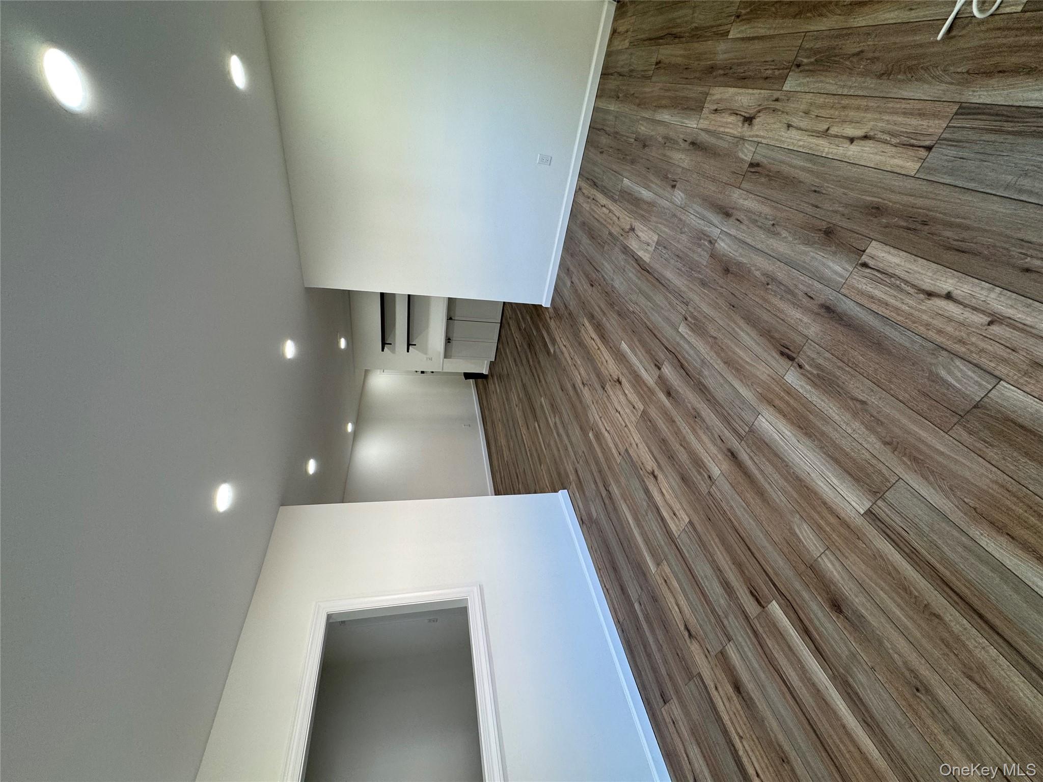 2449 I Union Avenue, Unit 34A Islip, NY 11751 - Photo 4 of 19 an empty room with wooden floor and entrance