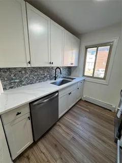 a kitchen with sink cabinets and wooden floor