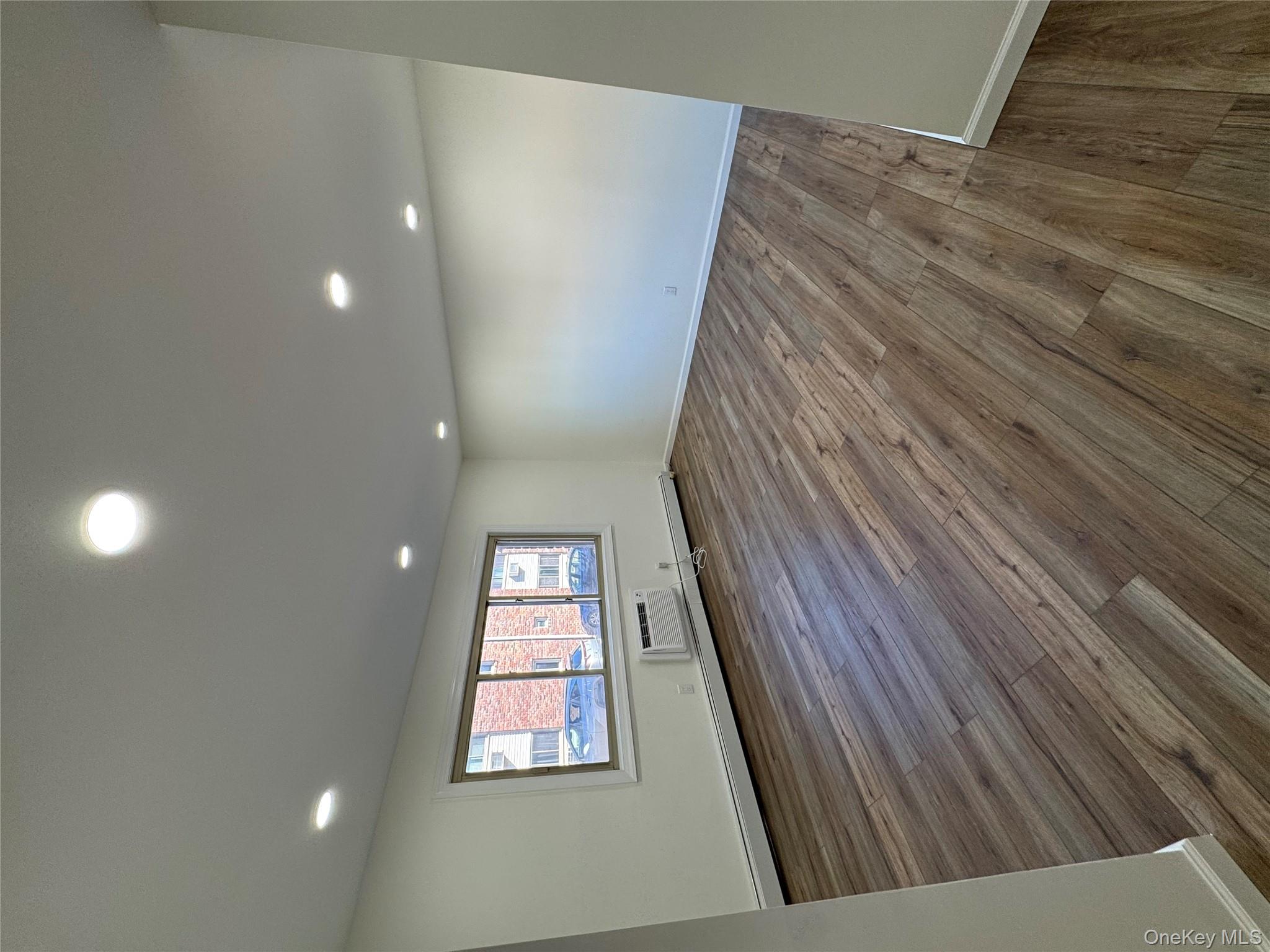 2449 I Union Avenue, Unit 34A Islip, NY 11751 - Photo 9 of 19 an empty room with wooden floor and windows