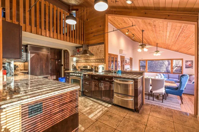 a large kitchen with stainless steel appliances granite countertop a sink and cabinets