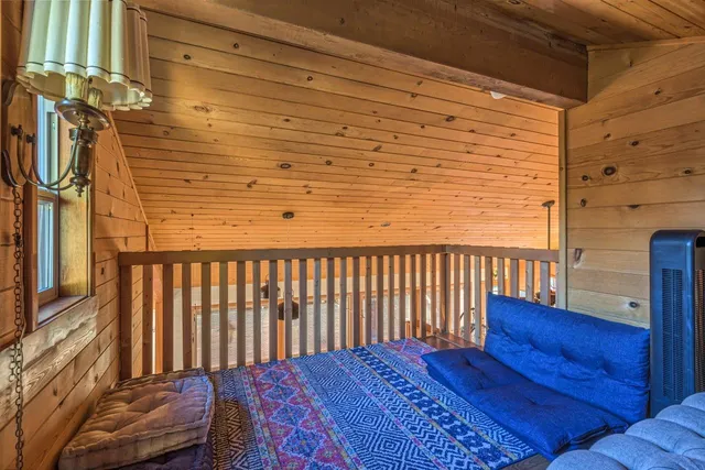 a bed sitting in a bedroom next to a window