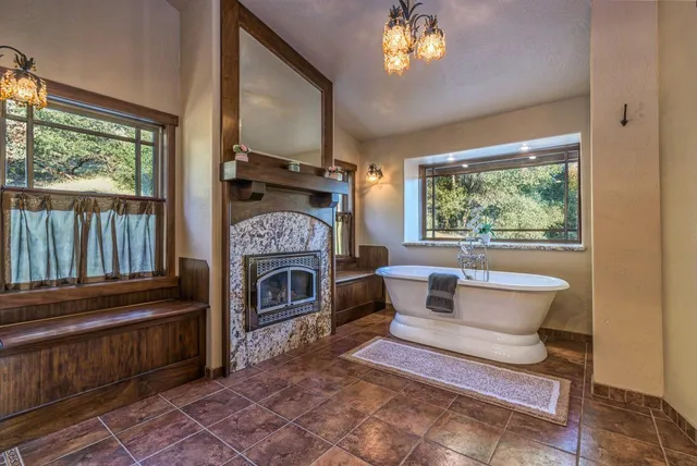 a view of a living room with a fireplace and windows