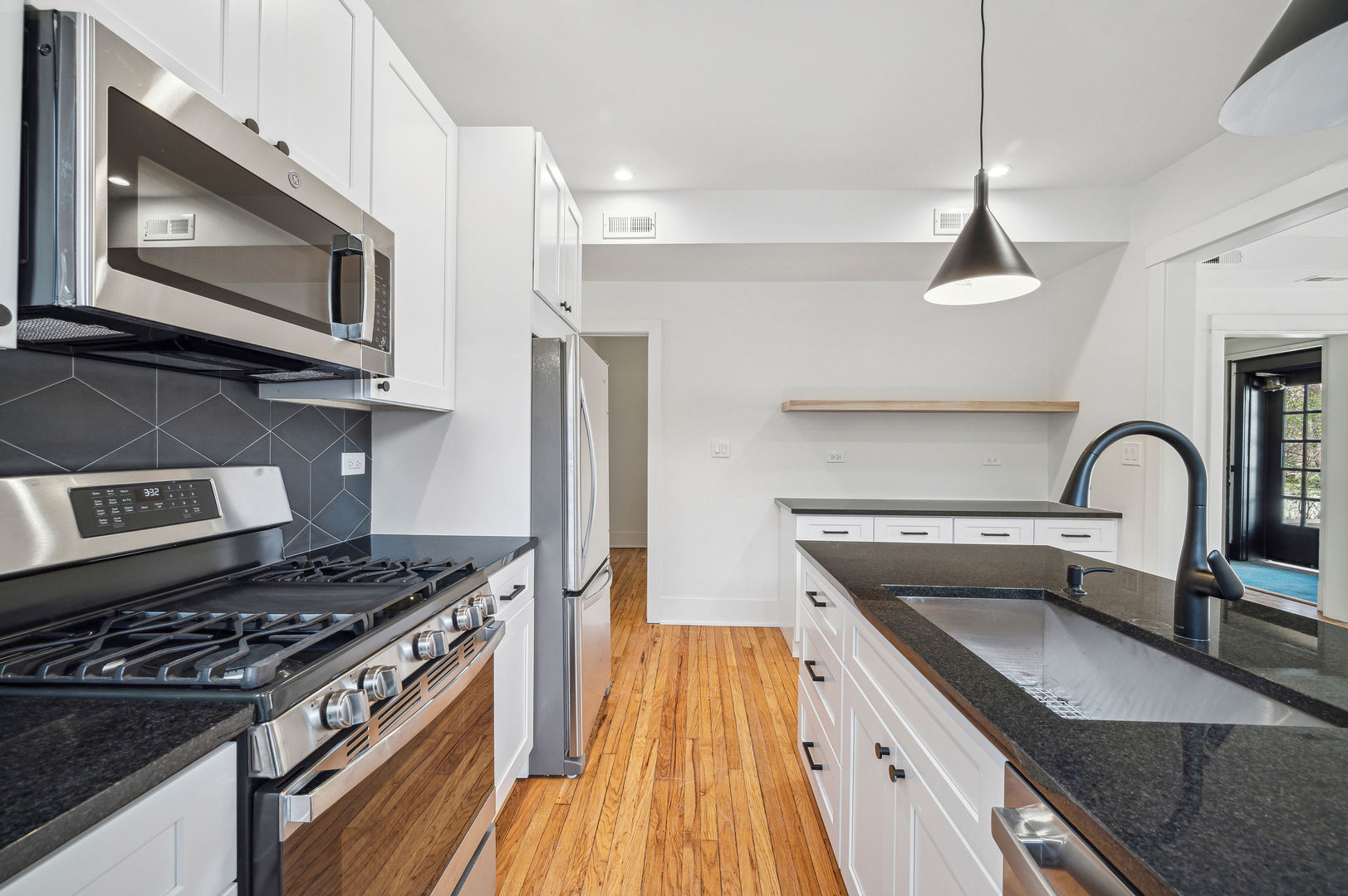 1928 Harrison Street, Unit 1 Evanston, IL 60201 - Photo 5 of 11 a kitchen with stainless steel appliances granite countertop a stove a sink dishwasher and a microwave oven with wooden floor