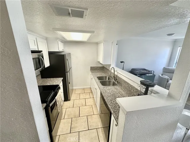 a kitchen with stainless steel appliances granite countertop a refrigerator stove and sink