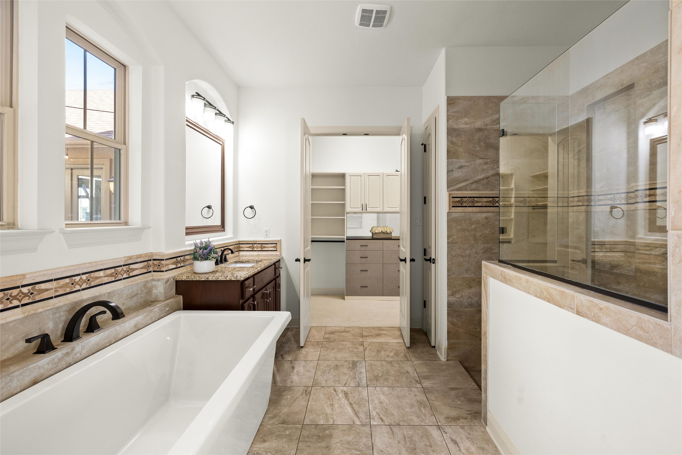6000 Osceola Trail Austin, TX 78738 - Photo 21 of 40 a large bathroom with a tub a double vanity sink a mirror and a shower