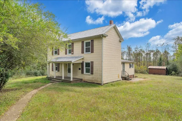 a view of a house with yard and sitting area