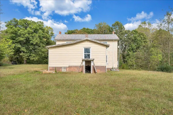 a view of a house with backyard and trees