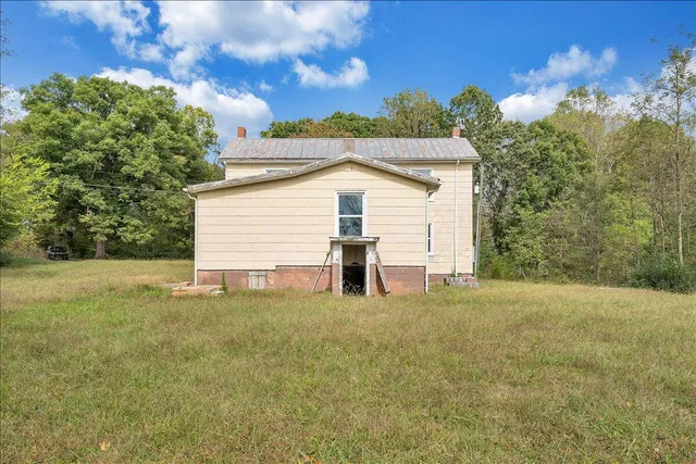a view of a house with backyard and trees