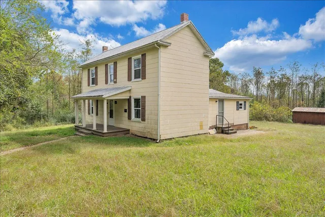 a view of a house with a yard and sitting area