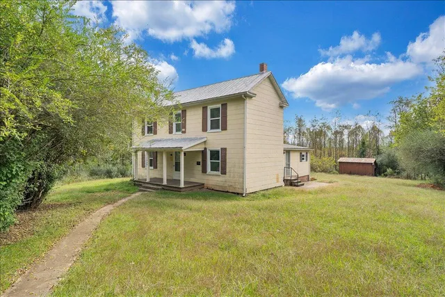 a view of a house with a yard and sitting area
