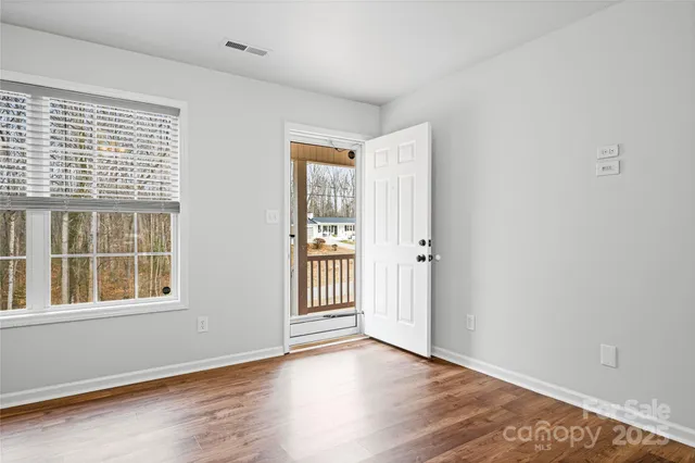 wooden floor in an empty room with a kitchen