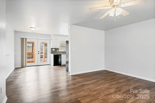 an empty room with a kitchen and a window