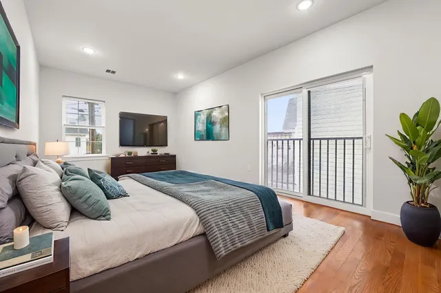 a bedroom with a bed a mirror and a flat screen tv