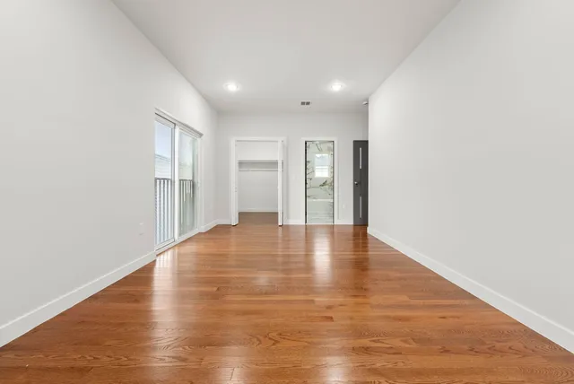 a view of empty room with wooden floor