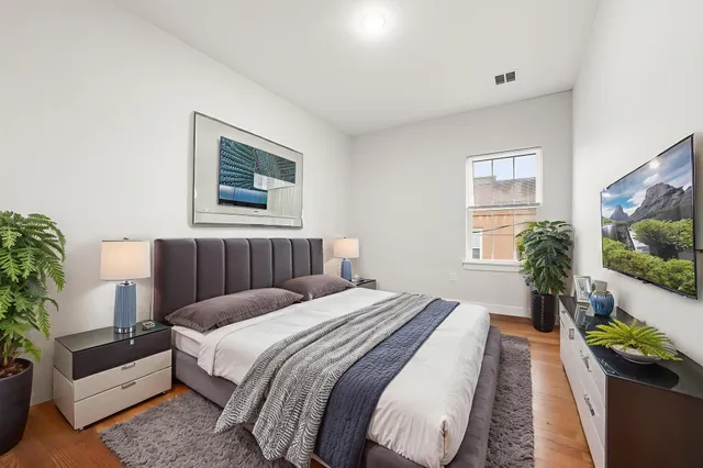 a bedroom with bed and a potted plant