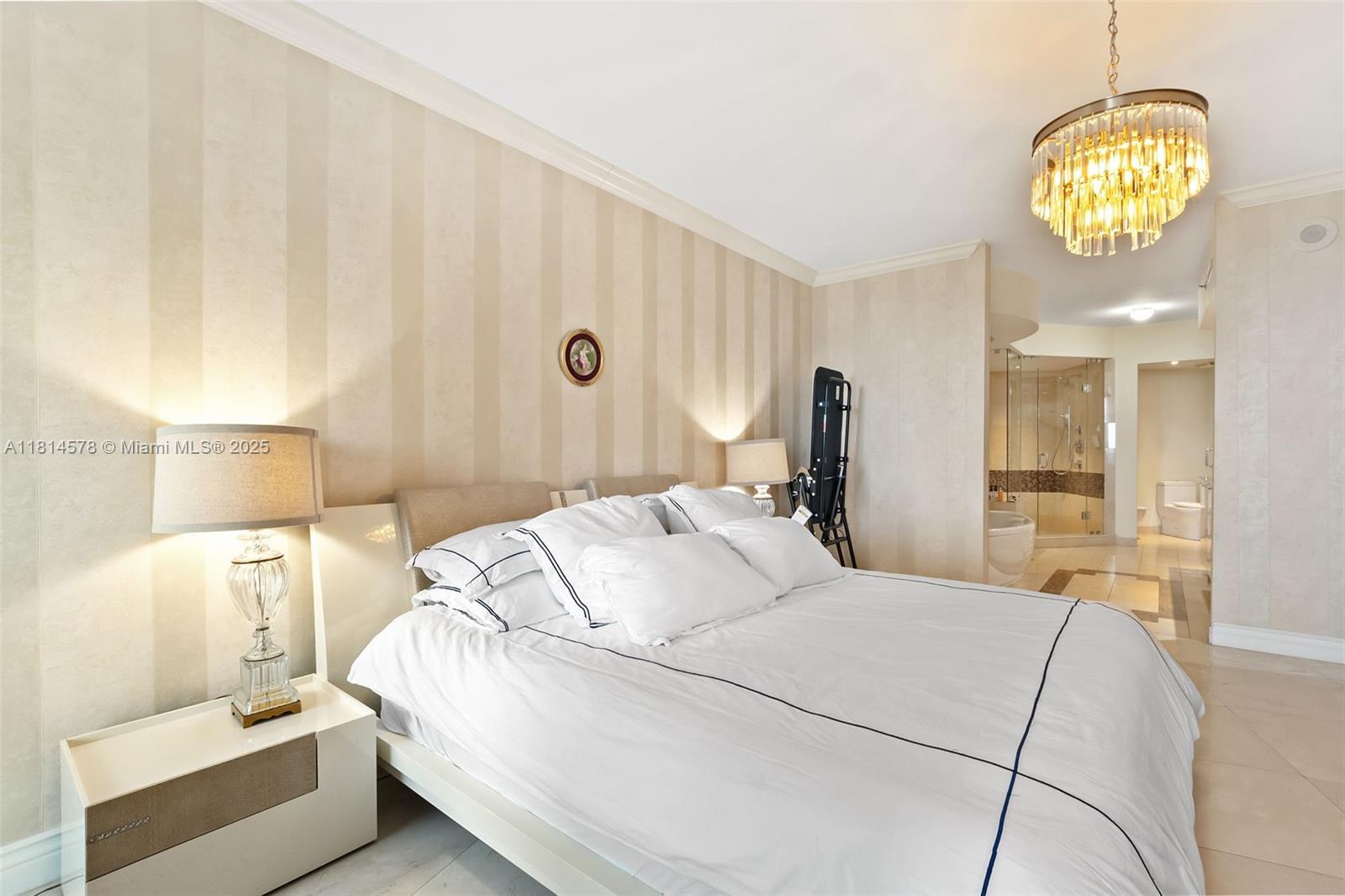18911 Collins Avenue, Unit 706 Sunny Isles Beach, FL 33160 - Photo 16 of 28 a bedroom with a bed and a chandelier
