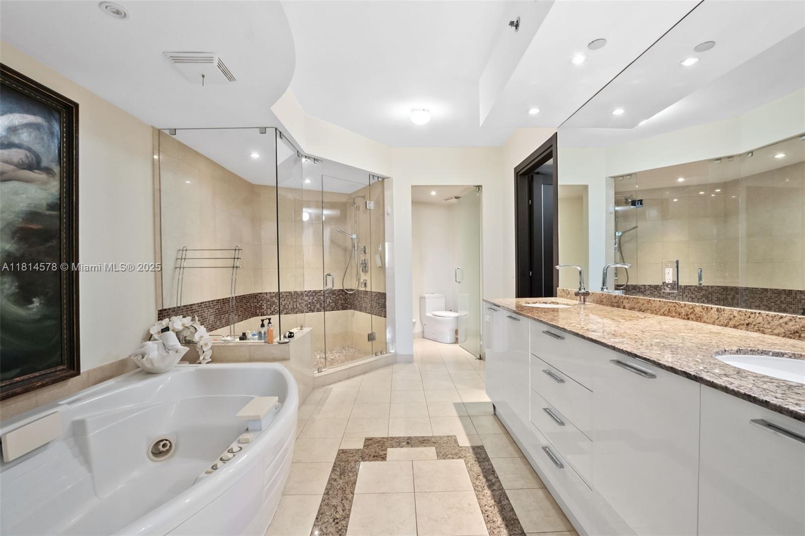 18911 Collins Avenue, Unit 706 Sunny Isles Beach, FL 33160 - Photo 18 of 28 a bathroom with a tub a double vanity sink and mirror