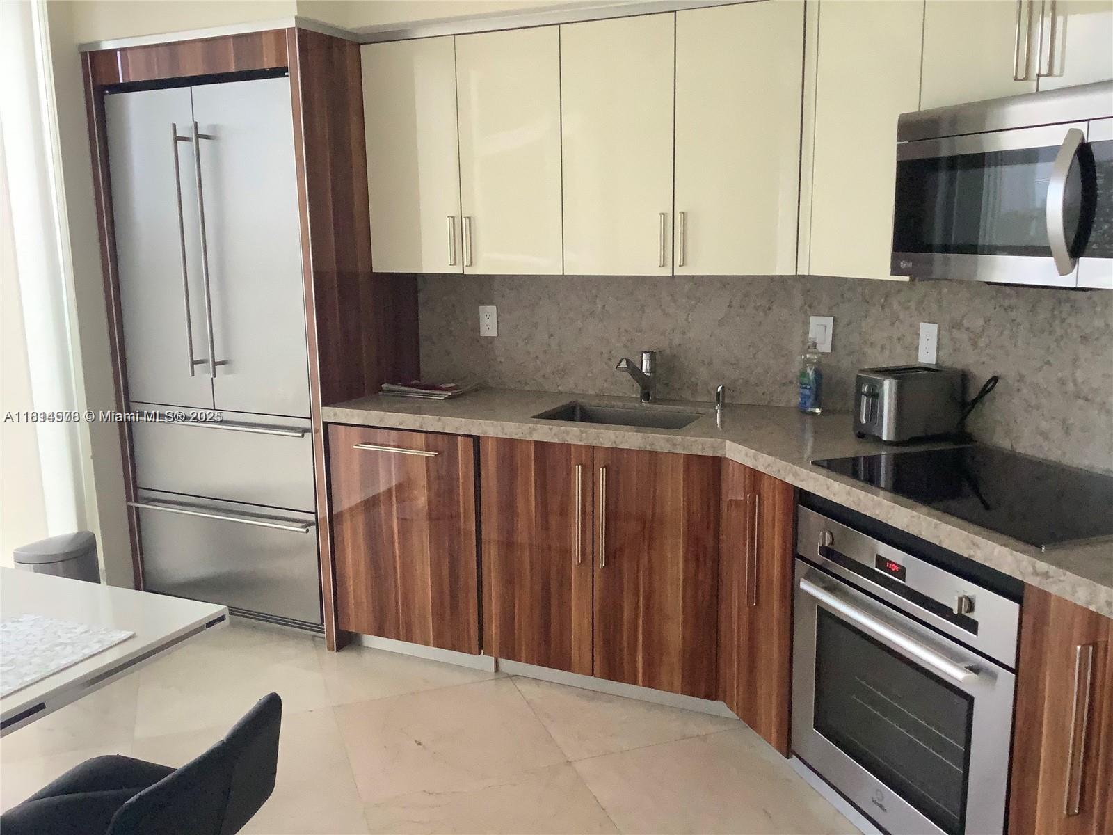 18911 Collins Avenue, Unit 706 Sunny Isles Beach, FL 33160 - Photo 2 of 28 a kitchen with appliances a sink and a counter top space