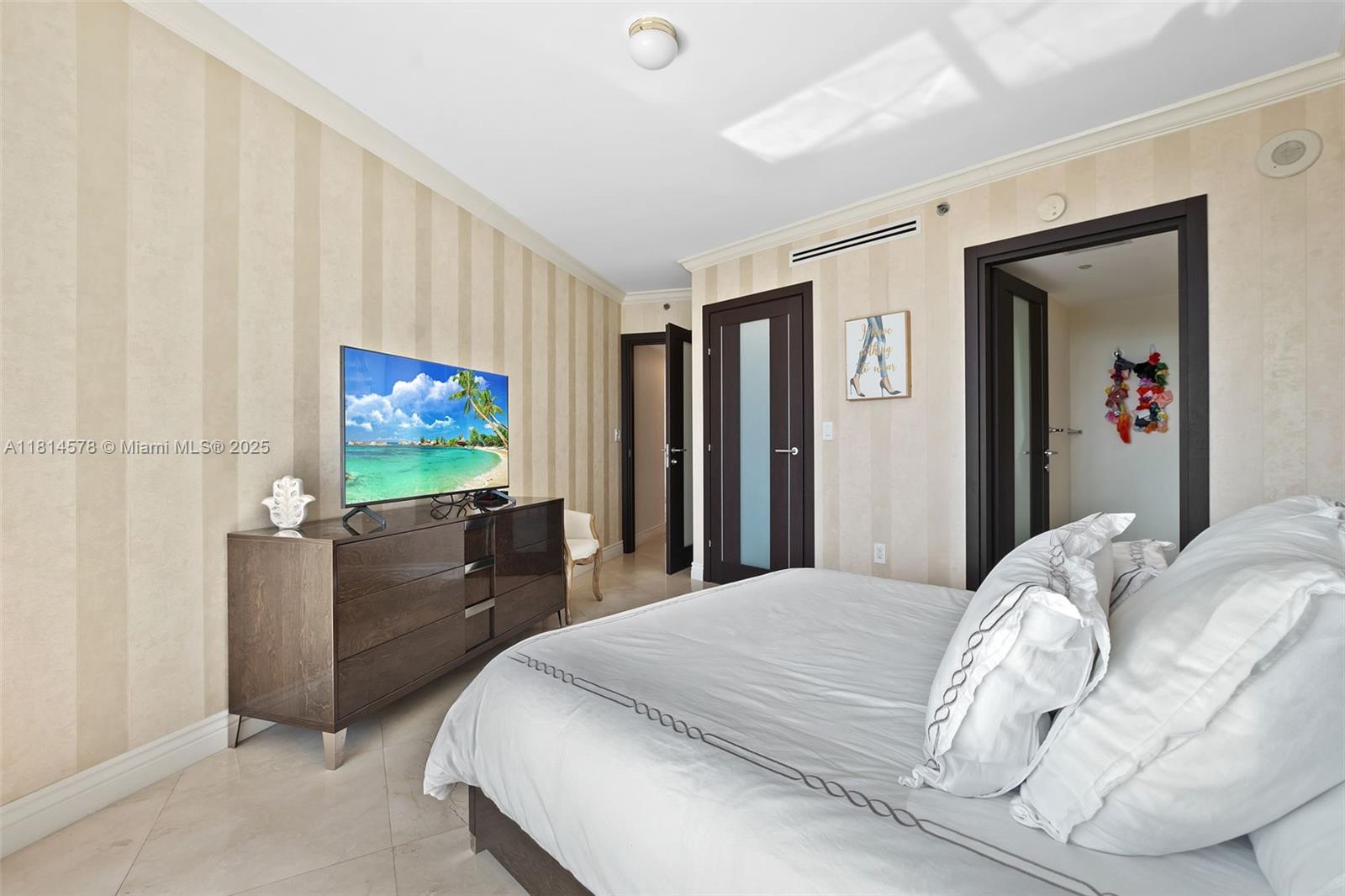 18911 Collins Avenue, Unit 706 Sunny Isles Beach, FL 33160 - Photo 22 of 28 a bedroom with a bed and a flat screen tv