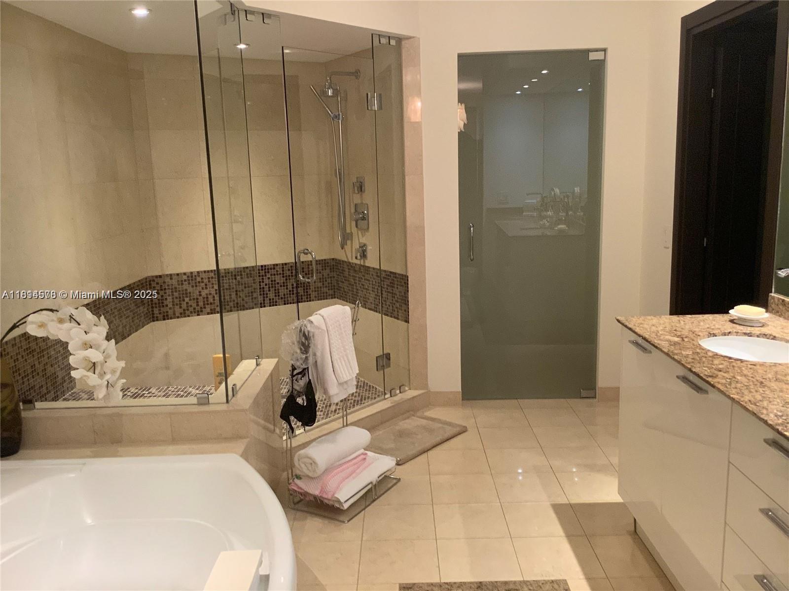 18911 Collins Avenue, Unit 706 Sunny Isles Beach, FL 33160 - Photo 27 of 28 a bathroom with a sink and mirror