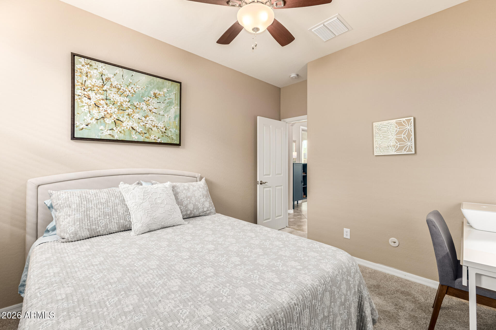 20594 West White Rock Road Buckeye, AZ 85396 - Photo 17 of 38 a bedroom with a large bed and a chandelier