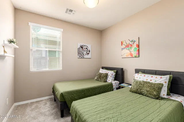 a bedroom with a bed and painting on the wall