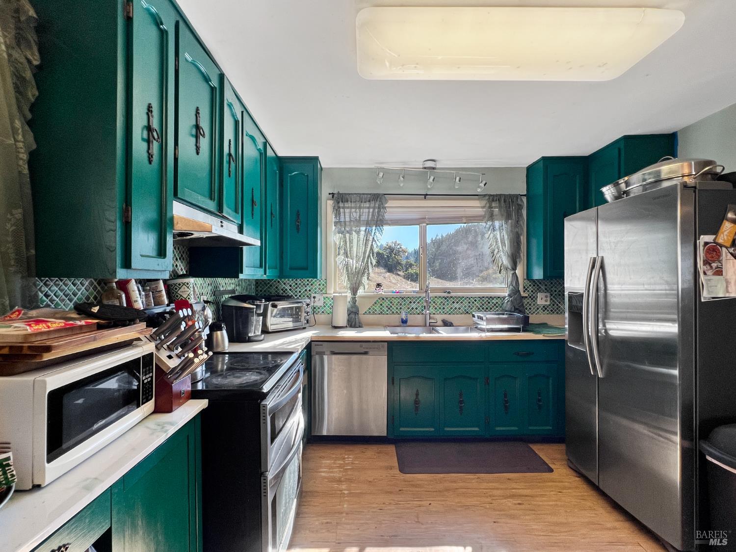 8600 Cave Creek Road Redwood Valley, CA 95470 - Photo 4 of 11 a kitchen with kitchen island a sink stove and refrigerator