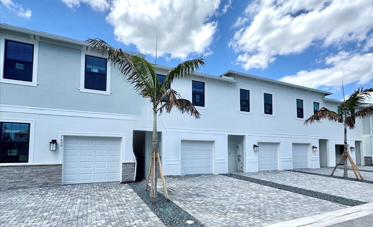 7594 Southwest Linus Lane, Unit LATITUDE 902 Stuart, FL 34997 - Photo 3 of 21 a front view of a house with a yard