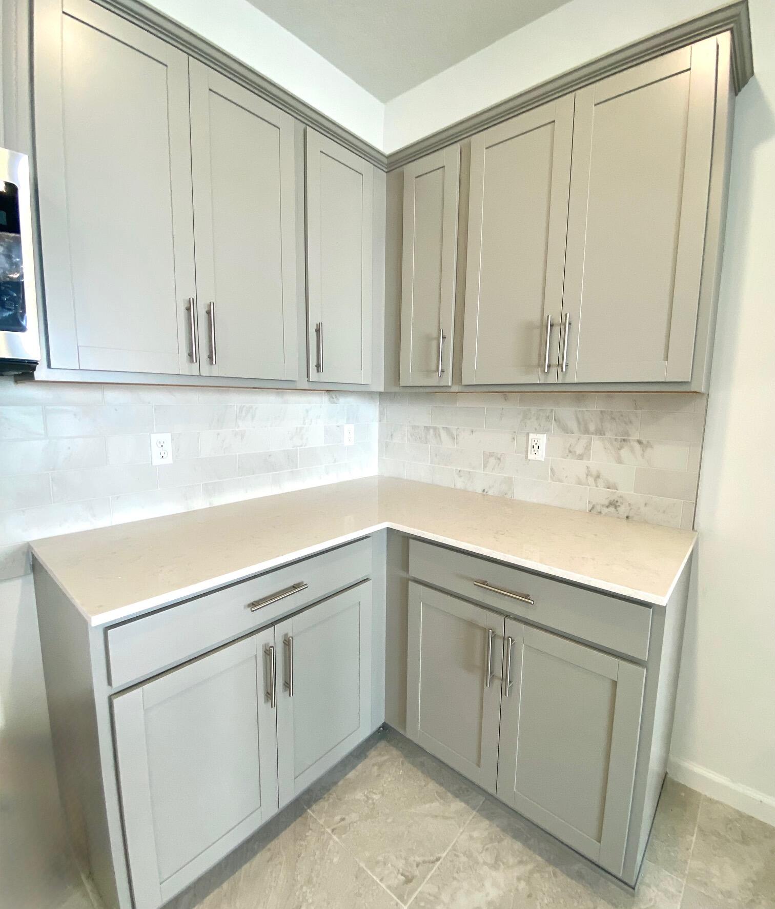 7594 Southwest Linus Lane, Unit LATITUDE 902 Stuart, FL 34997 - Photo 6 of 21 a kitchen with white cabinets