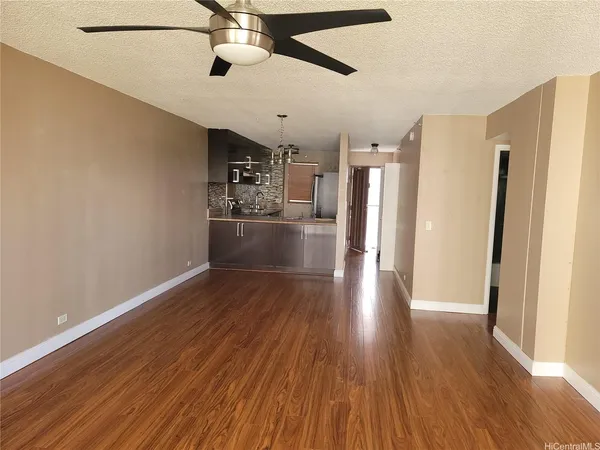 a view of a kitchen with a refrigerator a ceiling fan and wooden floor