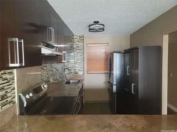 a kitchen with stainless steel appliances granite countertop a refrigerator and a sink