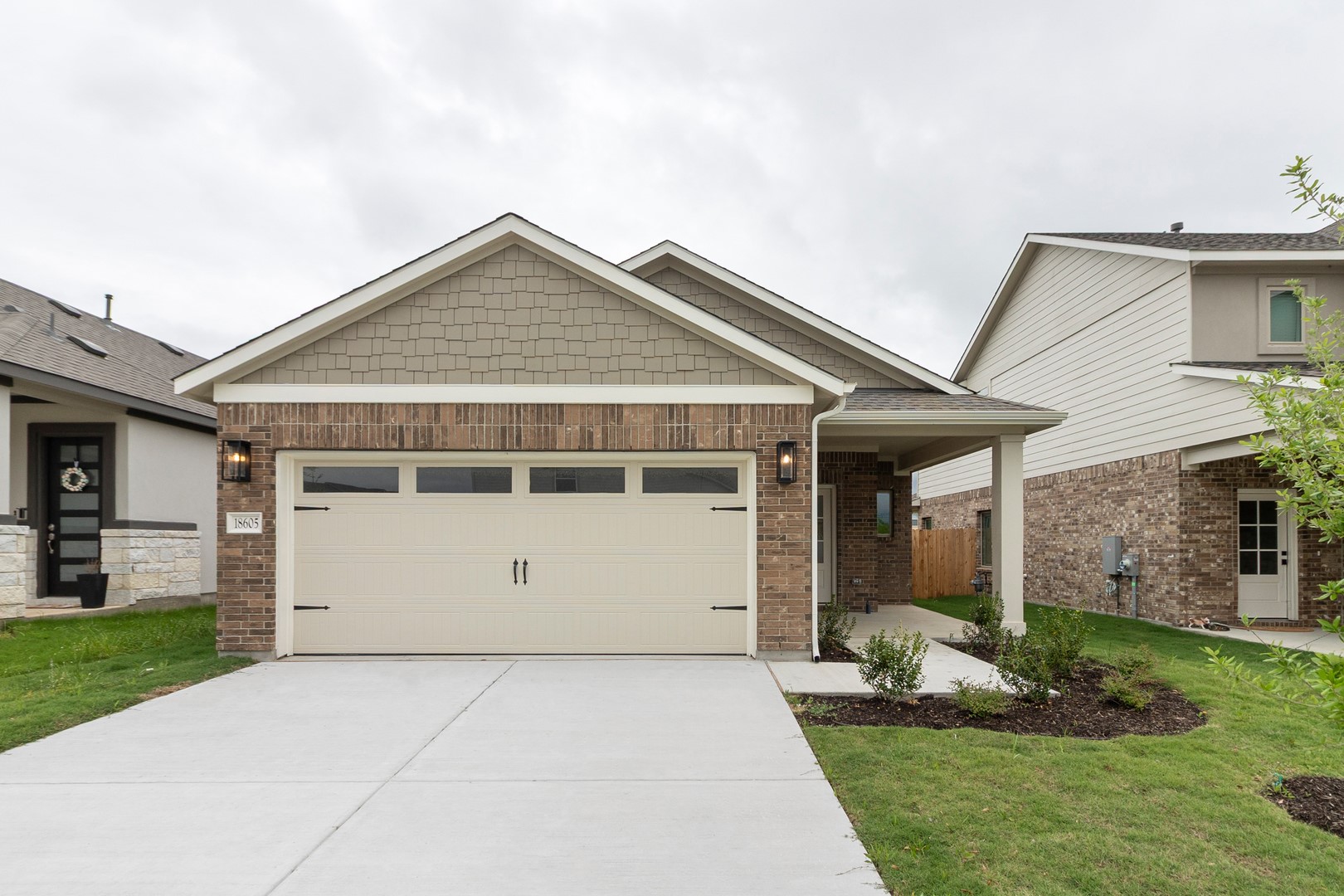 18605 Emu Lane Manor, TX 78653 - Photo 1 of 27 The property features a brick exterior with decorative siding, an attached garage, and a concrete driveway