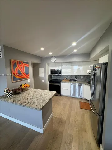 a kitchen with stainless steel appliances granite countertop a refrigerator and a stove