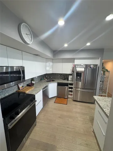 a large kitchen with stainless steel appliances and a stove top oven