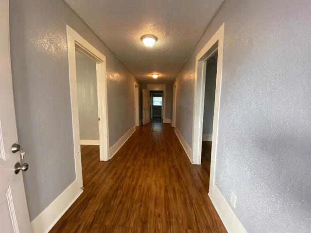 a view of a hallway with wooden floor