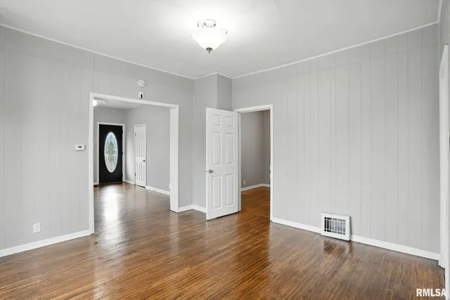 an empty room with wooden floor and closet
