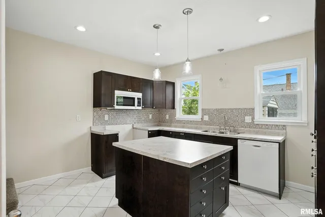 a kitchen with a sink a stove a microwave and wooden cabinets