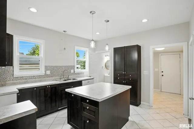a kitchen with a sink a stove a refrigerator and a dining table