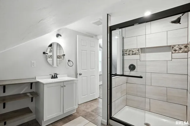 a bathroom with a double vanity sink a mirror and shower