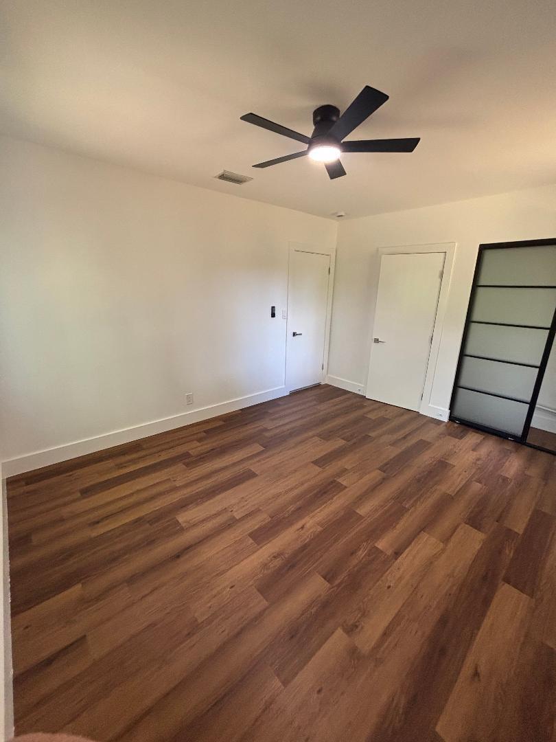 5724 Seton Drive Margate, FL 33063 - Photo 12 of 12 an empty room with wooden floor ceiling fan and windows