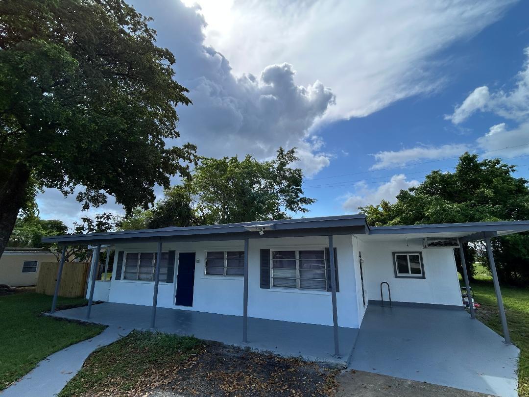 5724 Seton Drive Margate, FL 33063 - Photo 2 of 12 a front view of a house with a garden