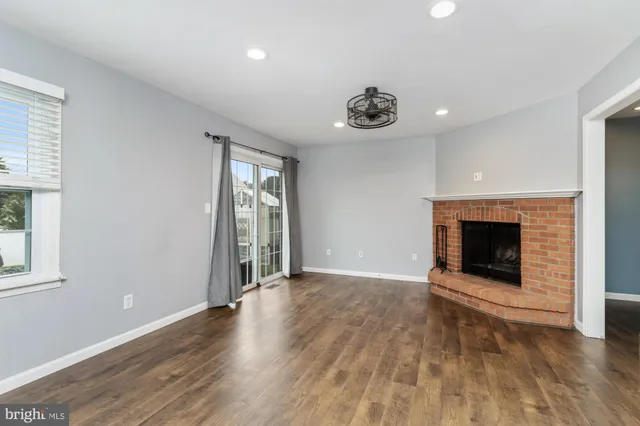 an empty room with wooden floor and fireplace