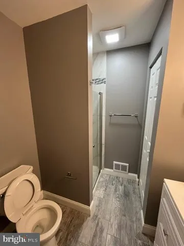 a bathroom with a granite countertop sink toilet and shower
