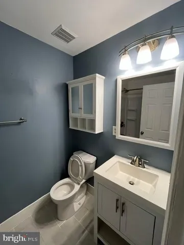a bathroom with a granite countertop toilet sink and mirror