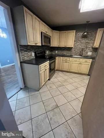 a kitchen with granite countertop a stove a sink a microwave and cabinets