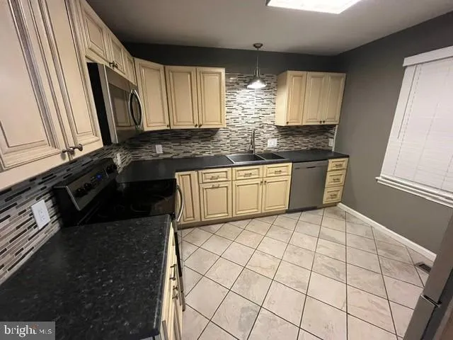 a kitchen with stainless steel appliances a sink a stove a microwave a counter top space and cabinets