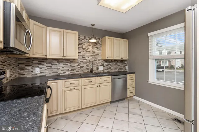 a kitchen with granite countertop a stove sink and cabinets