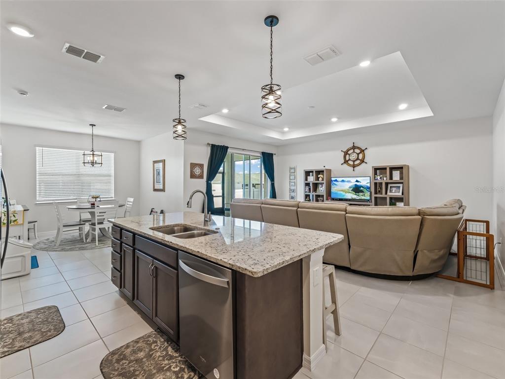 7206 Southwest 60th Lane Ocala, FL 34474 - Photo 12 of 50 a large kitchen with kitchen island a counter top space a sink stainless steel appliances and cabinets